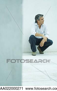 Stock Photography - mature man crouching, 
looking away, 
smiling, full 
length portrait. 
fotosearch - search 
stock photos, 
pictures, images, 
and photo clipart