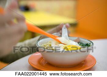 Stock Image - person eating 
noodle dish with 
egg, cropped view. 
fotosearch - search 
stock photos, 
pictures, images, 
and photo clipart