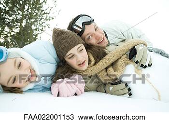 Stock Photo - three young friends 
reclining in snow, 
piled up, one 
smiling at camera. 
fotosearch - search 
stock photos, 
pictures, images, 
and photo clipart