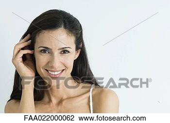Stock Photo - woman, pushing 
hair back, smiling 
at camera, portrait. 
fotosearch - search 
stock photos, 
pictures, images, 
and photo clipart