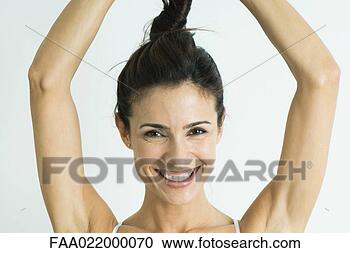 Stock Photography - woman twisting 
hair up above 
head, smiling 
at camera, portrait. 
fotosearch - search 
stock photos, 
pictures, images, 
and photo clipart