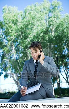 Stock Photo - young businessman 
sitting outdoors 
using laptop computer, 
writing. fotosearch 
- search stock 
photos, pictures, 
images, and photo 
clipart