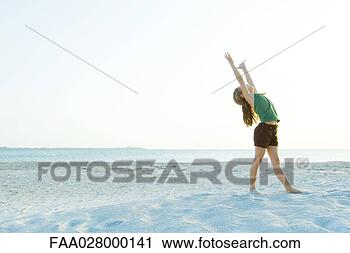 Stock Photography - little girl standing 
on the beach with 
arms raised,  
head back,  full. 
fotosearch - search 
stock photos, 
pictures, images, 
and photo clipart