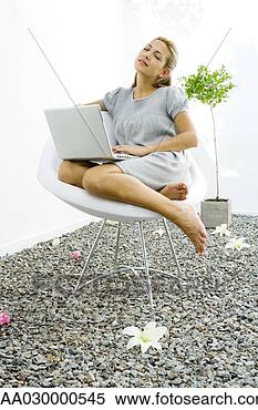 Stock Image - woman sitting 
in chair in rock 
garden,  holding 
laptop computer. 
fotosearch - search 
stock photos, 
pictures, images, 
and photo clipart