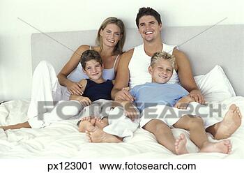 Stock Photography - husband and wife 
laying on bed 
with two sons. 
fotosearch - search 
stock photos, 
pictures, images, 
and photo clipart