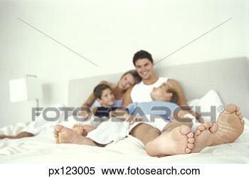 Stock Image - husband and wife 
laying on bed 
with two sons. 
fotosearch - search 
stock photos, 
pictures, images, 
and photo clipart