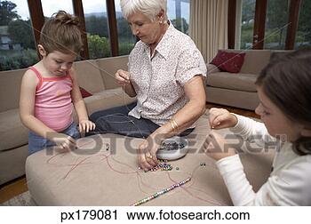 Stock Photography - grandmother stringing 
beads with granddaughters. 
fotosearch - search 
stock photos, 
pictures, images, 
and photo clipart