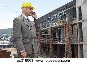 Stock Photography - foreman on cell 
phone at construction 
site. fotosearch 
- search stock 
photos, pictures, 
images, and photo 
clipart