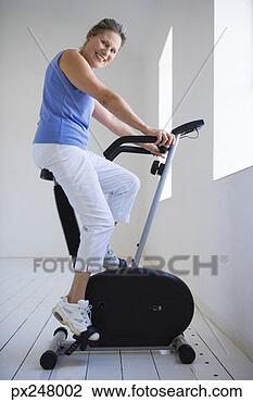 Banco de Imagem - sorrindo,  mulher, 
 usando,  exercício, 
 bicicleta. fotosearch 
- busca de fotos, 
imagens e clipart