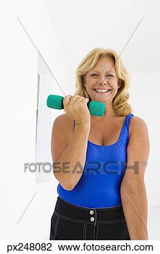 Stock Photo - woman lifting 
dumbbells. fotosearch 
- search stock 
photos, pictures, 
images, and photo 
clipart