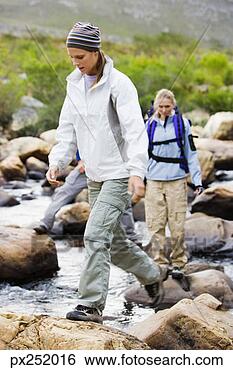 Stock Photo - friends walking 
across stream 
outdoors. fotosearch 
- search stock 
photos, pictures, 
images, and photo 
clipart