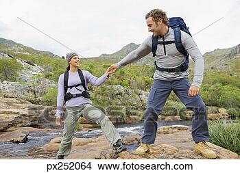Stock Photo - man helping woman 
across stream. 
fotosearch - search 
stock photos, 
pictures, images, 
and photo clipart
