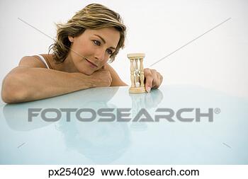 Arquivo Fotográficos - mulher,  ampulheta. 
fotosearch - busca 
de fotos, imagens 
e clipart