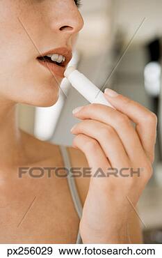 Stock Photograph - woman putting 
on lipgloss. fotosearch 
- search stock 
photos, pictures, 
images, and photo 
clipart