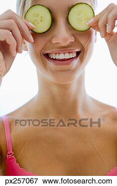 Picture - woman holding 
cucumber slices 
over eyes. fotosearch 
- search stock 
photos, pictures, 
images, and photo 
clipart