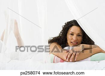 Stock Photo - woman lying in 
bed behind sheer 
curtain. fotosearch 
- search stock 
photos, pictures, 
images, and photo 
clipart