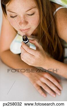 Stock Photo - young woman with 
small bottle of 
essential oil. 
fotosearch - search 
stock photos, 
pictures, images, 
and photo clipart