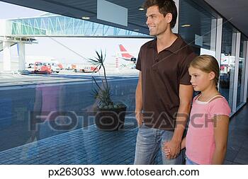 Stock Photo - father and daughter 
holding hands 
and looking out 
airport window. 
fotosearch - search 
stock photos, 
pictures, images, 
and photo clipart