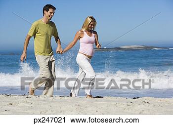 Stock Photography - pregnant couple 
walking on beach. 
fotosearch - search 
stock photos, 
pictures, images, 
and photo clipart