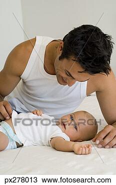 Banco de Imagem - pai,  bebê,  cama. 
fotosearch - busca 
de fotos, imagens 
e clipart