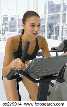Stock Photo - woman using exercise 
bike. fotosearch 
- search stock 
photos, pictures, 
images, and photo 
clipart