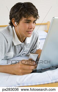 Stock Photo - teenage boy using 
laptop computer 
and mp3 player. 
fotosearch - search 
stock photos, 
pictures, images, 
and photo clipart