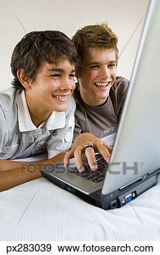 Stock Photograph - teenage boys using 
laptop computer. 
fotosearch - search 
stock photos, 
pictures, images, 
and photo clipart