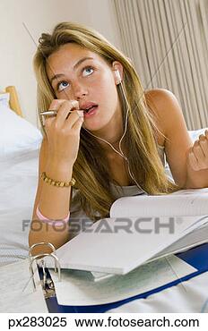 Stock Image - teenage girl listening 
to music while 
doing homework. 
fotosearch - search 
stock photos, 
pictures, images, 
and photo clipart