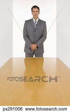 Stock Photo - businessman standing 
by table. fotosearch 
- search stock 
photos, pictures, 
images, and photo 
clipart
