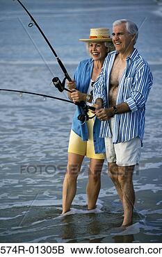 Stock Photo - senior man teaching 
a senior woman 
fishing at the 
beach. fotosearch 
- search stock 
photos, pictures, 
images, and photo 
clipart