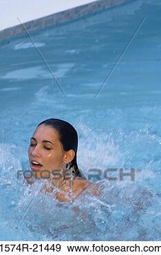 Stock Photograph - high angle view 
of a young woman 
swimming in a 
swimming pool. 
fotosearch - search 
stock photos, 
pictures, images, 
and photo clipart
