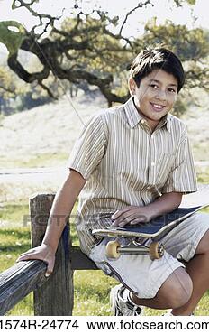 Stock Photo - portrait of a 
boy holding a 
skateboard smiling. 
fotosearch - search 
stock photos, 
pictures, images, 
and photo clipart