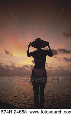 Stock Photo - silhouette of 
a young woman 
holding a hat, 
maldives. fotosearch 
- search stock 
photos, pictures, 
images, and photo 
clipart