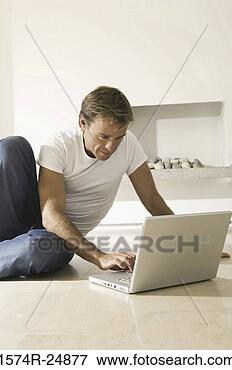 Picture - young man using 
a laptop on the 
floor. fotosearch 
- search stock 
photos, pictures, 
images, and photo 
clipart
