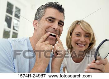 Picture - mature man applying 
a teeth whitening 
strip to his teeth 
with a mid. fotosearch 
- search stock 
photos, pictures, 
images, and photo 
clipart