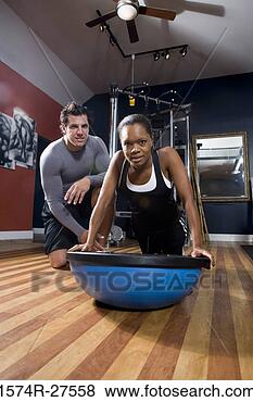 Stock Photo - portrait of a 
trainer instructing 
a young woman 
on a fitness ball 
in. fotosearch 
- search stock 
photos, pictures, 
images, and photo 
clipart