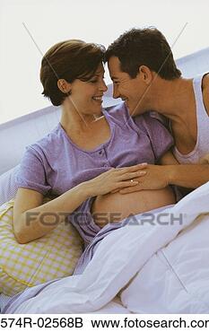 Stock Photo - husband lying 
in bed with his 
pregnant wife. 
fotosearch - search 
stock photos, 
pictures, images, 
and photo clipart
