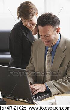 Stock Image - close-up of a 
businessman working 
on a laptop with 
a businesswoman. 
fotosearch - search 
stock photos, 
pictures, images, 
and photo clipart