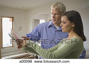 Stock Photo - young white couple 
looking at a paint 
color swatch. 
fotosearch - search 
stock photos, 
pictures, images, 
and photo clipart