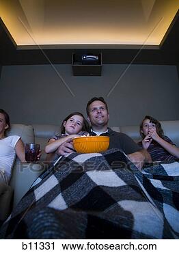 Stock Photography - father and daughters 
watching movie 
in home theater. 
fotosearch - search 
stock photos, 
pictures, images, 
and photo clipart