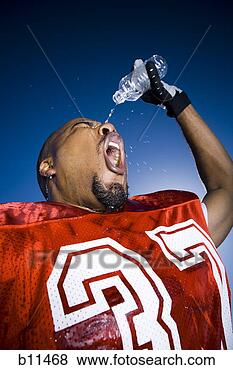 Stock Photo - football player 
cooling off with 
water. fotosearch 
- search stock 
photos, pictures, 
images, and photo 
clipart
