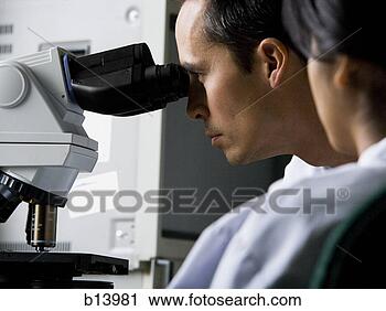 Stock Photography - male laboratory 
technician looking 
in microscope. 
fotosearch - search 
stock photos, 
pictures, images, 
and photo clipart