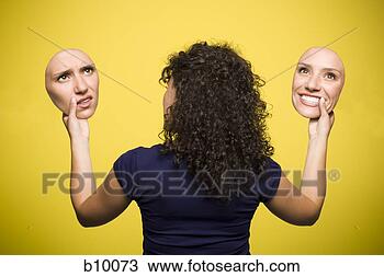 Stock Photo - rear view of a 
young woman holding 
cutouts of her 
face with two. 
fotosearch - search 
stock photos, 
pictures, images, 
and photo clipart
