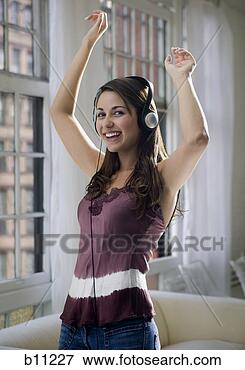 Picture - young woman listening 
to music on headphones 
and dancing. fotosearch 
- search stock 
photos, pictures, 
images, and photo 
clipart