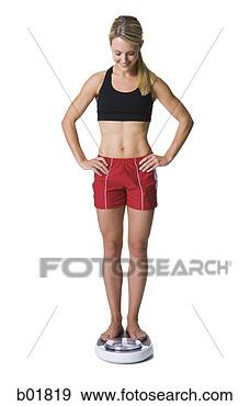 Stock Photograph - young woman standing 
on a bathroom 
scale. fotosearch 
- search stock 
photos, pictures, 
images, and photo 
clipart