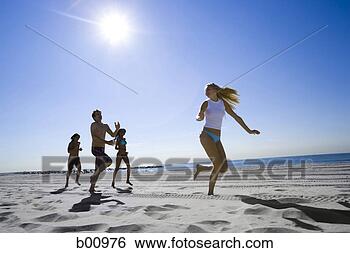 Stock Photo - low angle view 
of four young 
people running 
on the beach. 
fotosearch - search 
stock photos, 
pictures, images, 
and photo clipart