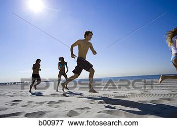 Picture - low angle view 
of four young 
people running 
on the beach. 
fotosearch - search 
stock photos, 
pictures, images, 
and photo clipart