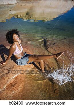 Arquivo de Fotografias - alto,   ângulo, 
  vista,   jovem, 
  mulher,   sentando, 
  rocha. fotosearch 
- busca de fotos, 
imagens e clipart