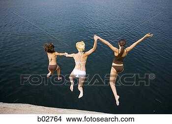 Stock Photo - high angle view 
of three young 
women jumping 
into a lake. fotosearch 
- search stock 
photos, pictures, 
images, and photo 
clipart