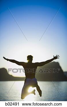 Stock Photography - rear view of a 
young man diving 
in a lake. fotosearch 
- search stock 
photos, pictures, 
images, and photo 
clipart
